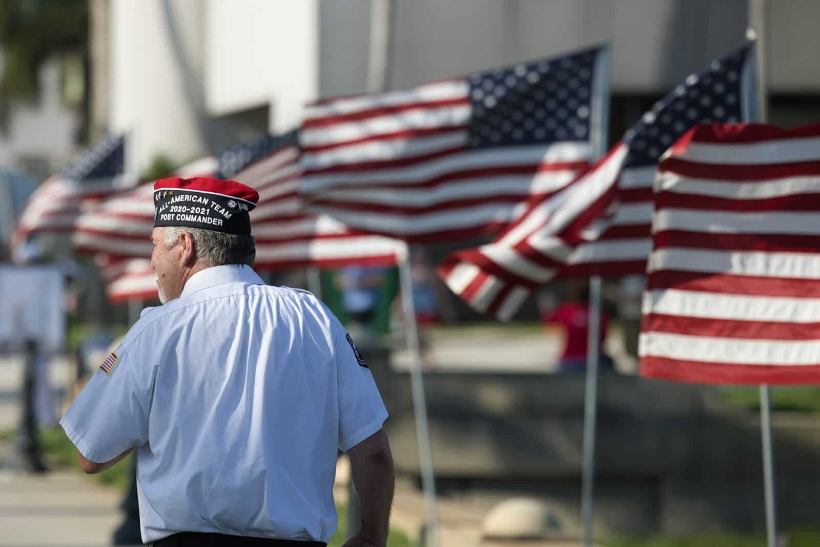 a man standing in front of a row of american flags